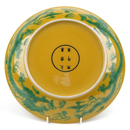 80 - A Chinese porcelain charger hand painted with dragons chasing the flaming pearl, onto a yellow groun... 