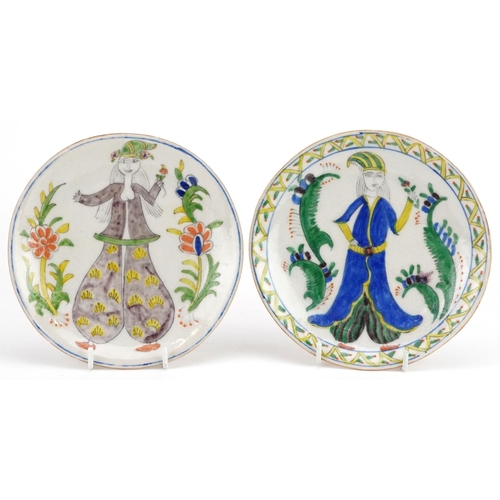 112 - A pair of Turkish Ottoman Kutahya plates hand painted with a figures, 15.5cm in diameter.