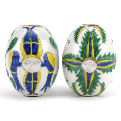 151 - Two Turkish Ottoman Kutahya Armenian pottery balls hand painted with faces, 7cm in length.