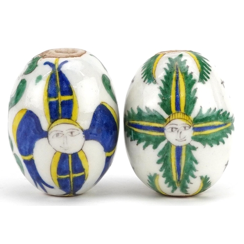 151 - Two Turkish Ottoman Kutahya Armenian pottery balls hand painted with faces, 7cm in length.