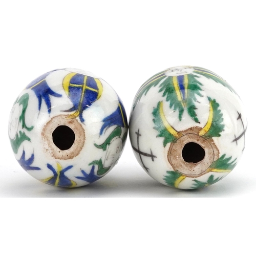 151 - Two Turkish Ottoman Kutahya Armenian pottery balls hand painted with faces, 7cm in length.