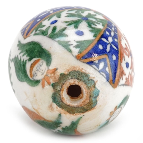 115 - A Turkish Ottoman Kutahya Armenian pottery hanging ball hand painted with faces and foliage, 10.5cm ... 