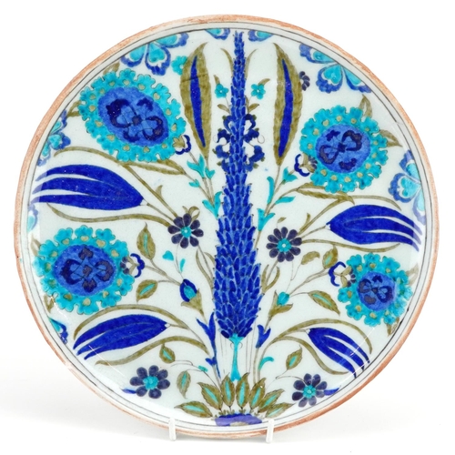 150 - A Turkish Ottoman Iznik pottery plate hand painted with flowers, 29.5cm in diameter.