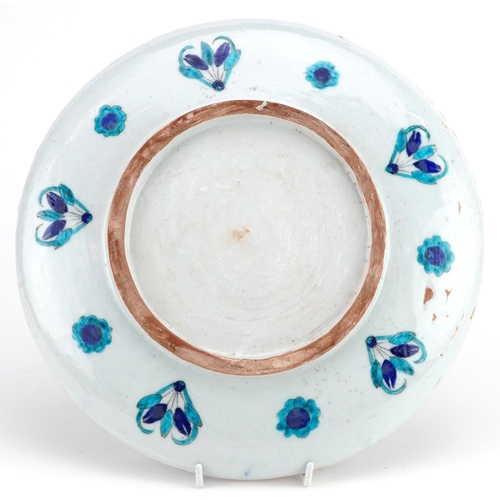 150 - A Turkish Ottoman Iznik pottery plate hand painted with flowers, 29.5cm in diameter.