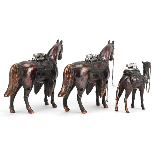  Three bronzed spelter table lighters in the form of horses and a camel, the largest 19cm in length.