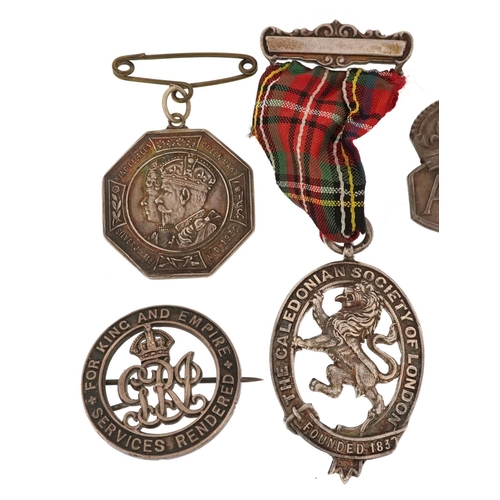  A collection of military interest silver badges and a Caledonian Society of London jewel, including ... 