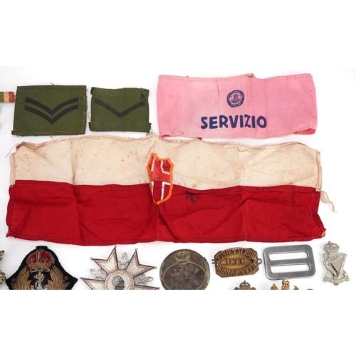 2453 - A large collection of British militaria including cap badges, buttons, arm bands and cloth patches.