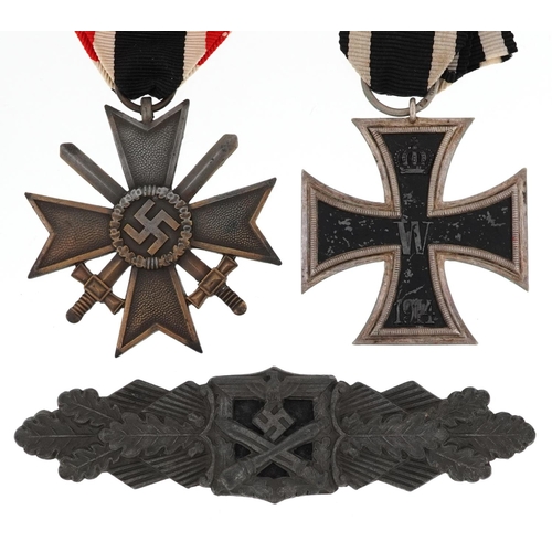 2419 - German militaria comprising an Iron Cross, War Merit Cross with swords and cap badge.