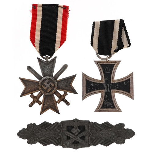 2419 - German militaria comprising an Iron Cross, War Merit Cross with swords and cap badge.