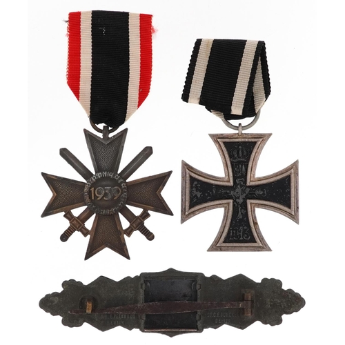 2419 - German militaria comprising an Iron Cross, War Merit Cross with swords and cap badge.