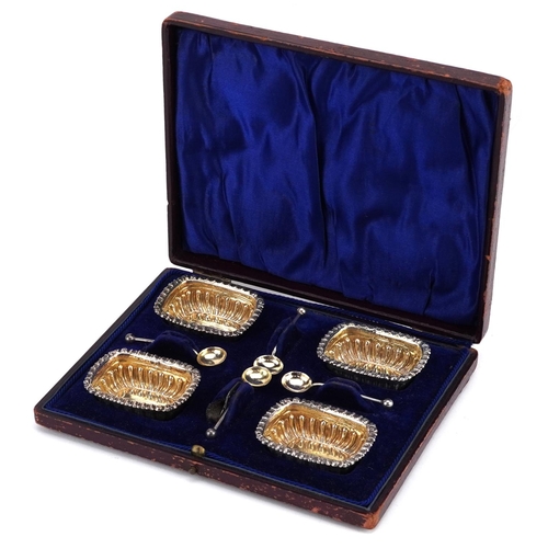 541 - William Devenport, a set of four Edwardian silver open salts with spoons housed in a velvet and silk... 