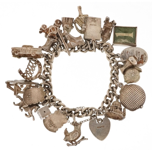 3662 - A silver charm bracelet with a collection of mostly silver charms including an emergency one pound n... 