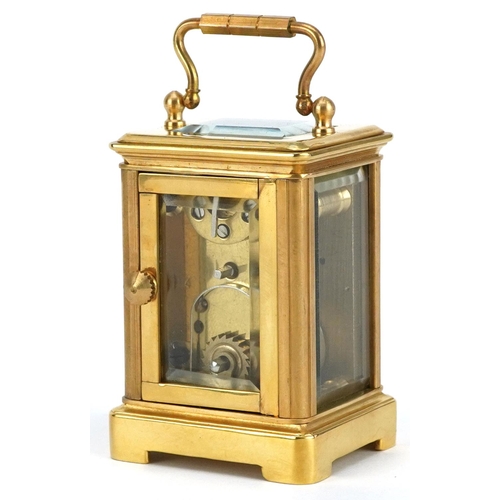 184 - A miniature brass cased carriage clock with swing handle, 8cm high.