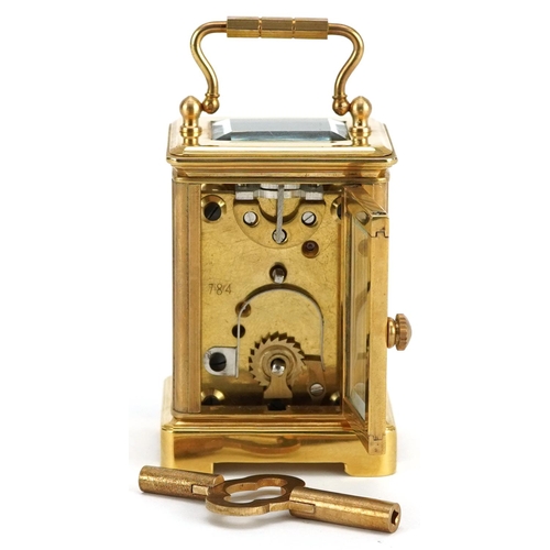 184 - A miniature brass cased carriage clock with swing handle, 8cm high.