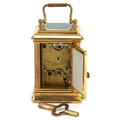 94 - A miniature brass cased carriage clock with swing handle and Sèvres style panels hand painted with P... 