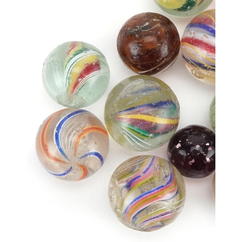 1318 - A collection of fourteen glass marbles, the majority with latticino swirls, variously sized.