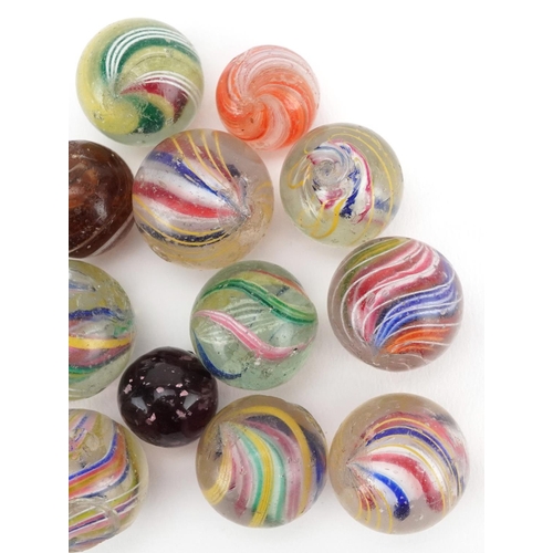 1318 - A collection of fourteen glass marbles, the majority with latticino swirls, variously sized.