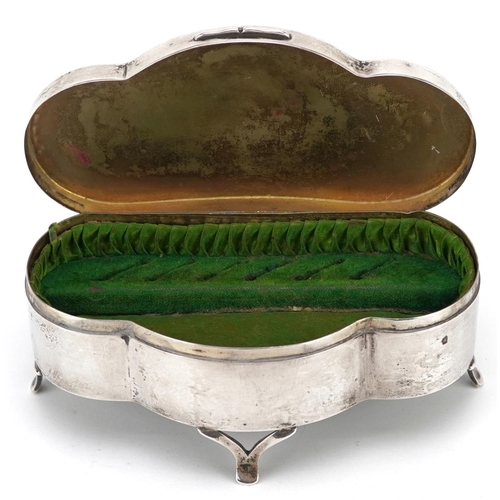 502 - D Bros., an Edwardian shaped silver jewel box raised on three feet having hinged lid and fitted inte... 