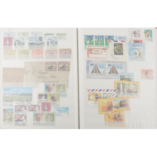 2218 - Red stamp album containing 19th century and later commonwealth stamps, mainly Papua, many cricket re... 