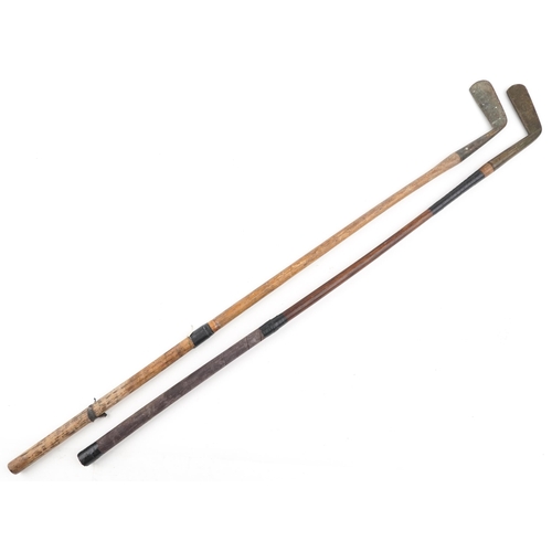 2297 - Two vintage hickory shafted brass headed golf clubs, one by Elverys, 85cm in length.