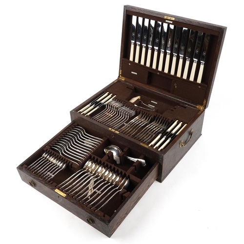 593 - Mappin & Webb, an oak canteen of silver plated cutlery with brass carry handles, 49cm wide.