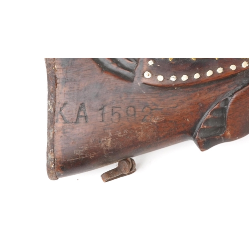 2554 - An antique Middle Eastern double barrel flintlock rifle, the wooden stock carved with a serpent head... 