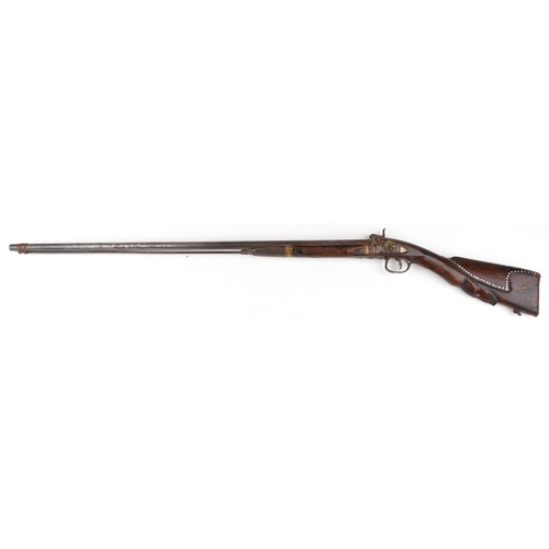 2554 - An antique Middle Eastern double barrel flintlock rifle, the wooden stock carved with a serpent head... 