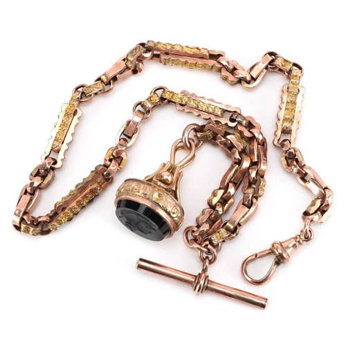  A Victorian 9ct rose gold watch chain with T bar and black onyx intaglio seal fob carved with a Roma... 