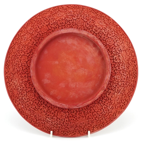 398 - A Chinese cinnabar lacquered circular plate, 20th century, profusely decorated in relief, 29cm in di... 