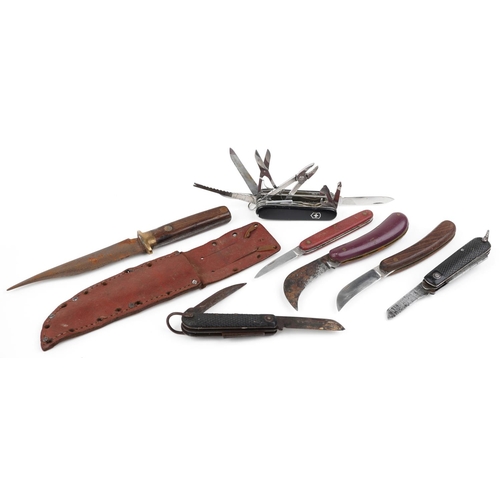 2498 - A group of six folding penknives together with an early 20th wooden handled knife in a leather sheat... 