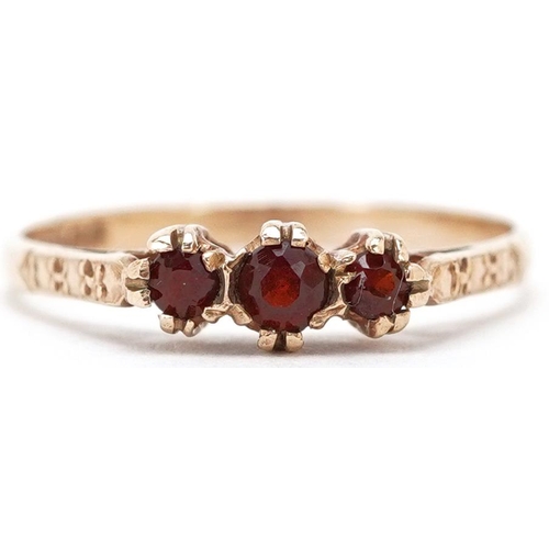 3471 - A 9ct gold garnet three stone ring, size P, 1.4g.