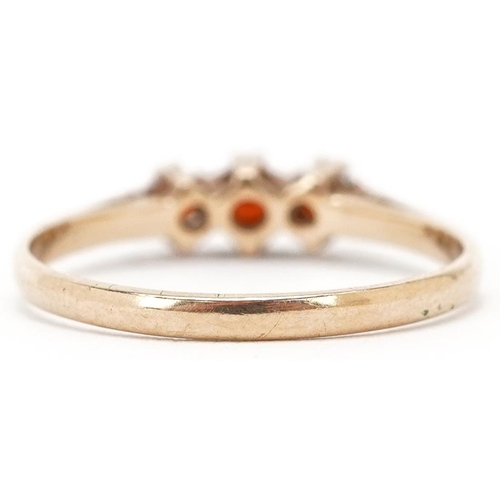 3471 - A 9ct gold garnet three stone ring, size P, 1.4g.