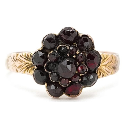 3463 - An antique unmarked gold Bohemian garnet flower head ring with floral engraved shoulders, size U, 3.... 