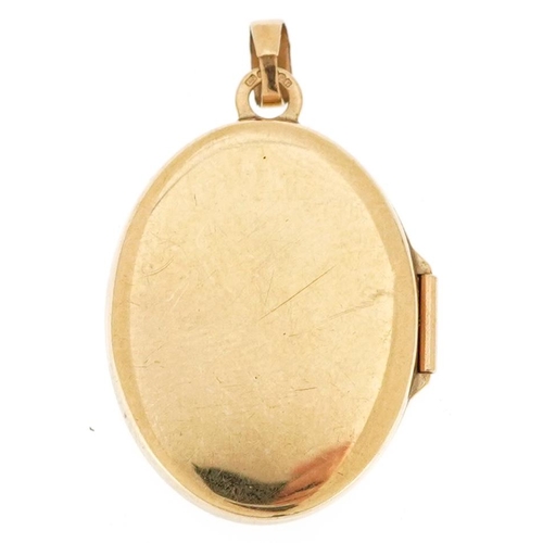 3192 - A 9ct gold green enamel oval locket, 2.6cm high, 1.8g.