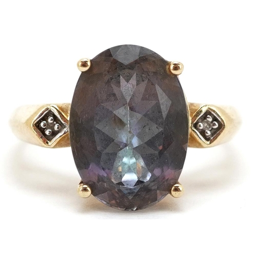 3120 - A 10ct gold purple/blue colour changing solitaire ring with diamond set shoulders, the stone 13.8mm ... 