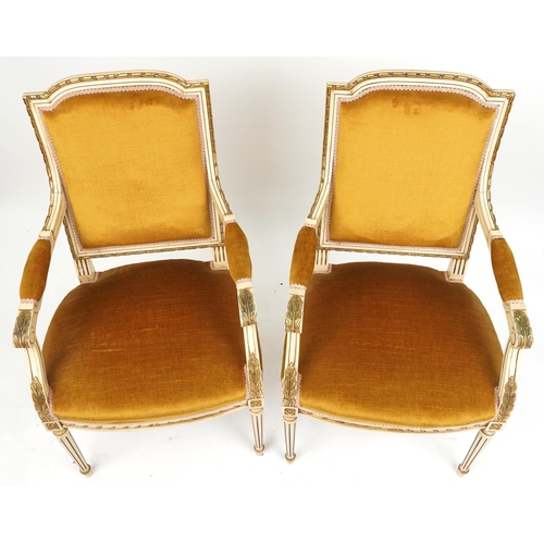 2019 - A pair of 20th century French cream and gilt painted salon armchairs upholstered in golden velour, r... 