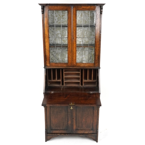 2053 - An early 20th century Arts & Crafts oak bureau bookcase with leaded glazed doors, a fall front above... 