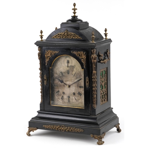 A large ebonised and gilt metal mounted mantle clock, the silvered dial having black Roman numerals, striking on a bell, raised on scroll feet, 70cm H x 45cm W x 29cm.