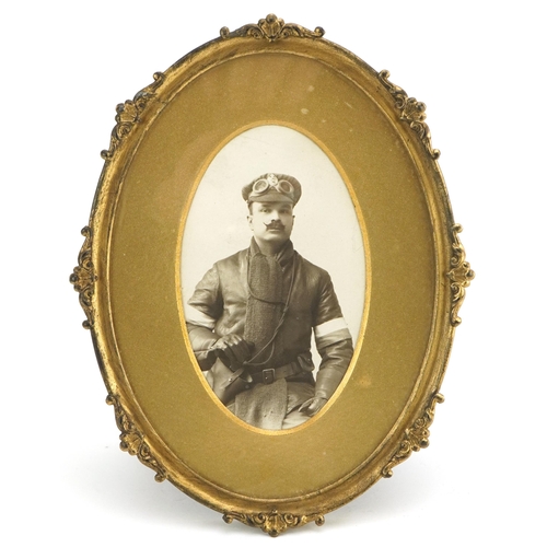 2432 - A gilt metal oval photograph frame, circa 1920, inset a black and white photograph of a military pil... 