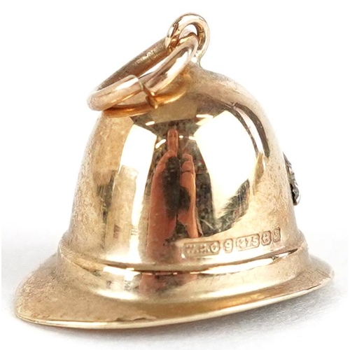 3653 - A 9ct gold charm in the form of a Police helmet, 14.8mm wide, 1.2g.