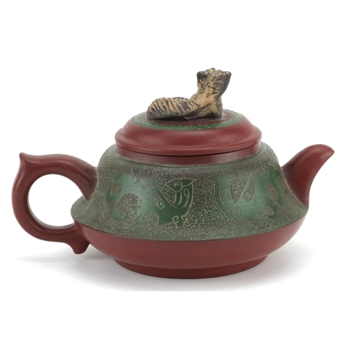  A Chinese Yixing stoneware teapot, early 20th century, with a green glaze finish, bearing circular c... 