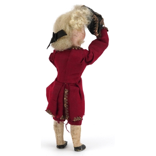  A 19th century French bisque headed diminutive doll with spring loaded arm, wearing period costume, ... 