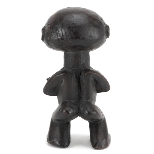 199 - An African squat figure standing four square, probably Kuba, 20th century, dark polished brown patin... 