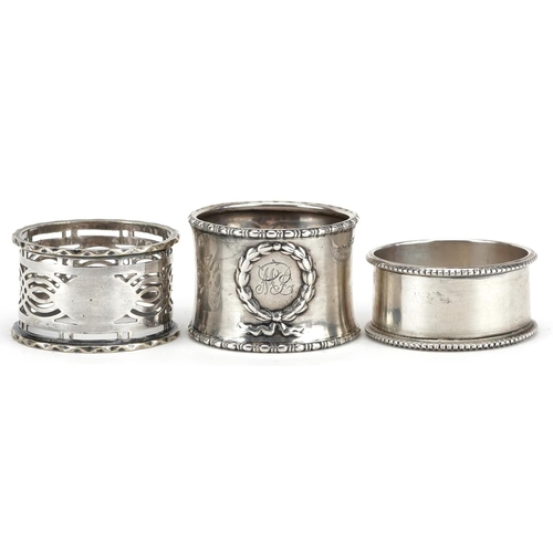 551 - Two circular silver napkin rings and a white metal pierced napkin ring, weighable silver 33.4g.