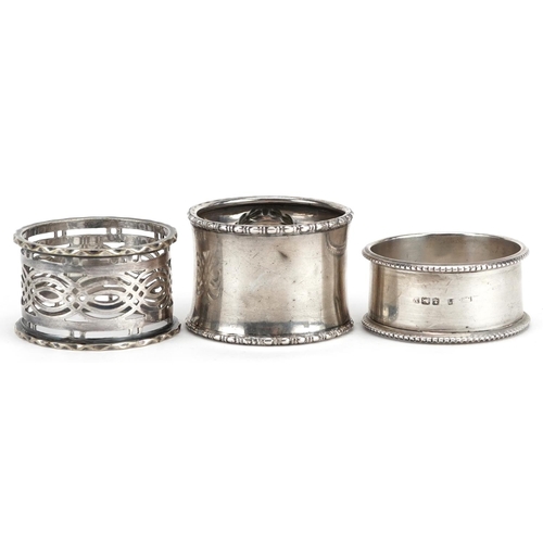 551 - Two circular silver napkin rings and a white metal pierced napkin ring, weighable silver 33.4g.