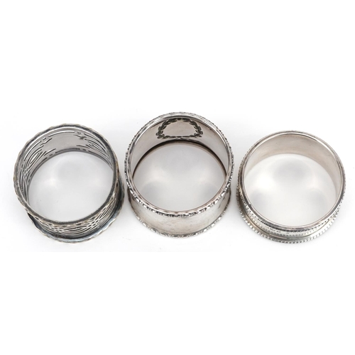 551 - Two circular silver napkin rings and a white metal pierced napkin ring, weighable silver 33.4g.