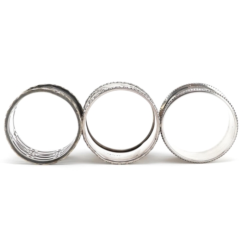 551 - Two circular silver napkin rings and a white metal pierced napkin ring, weighable silver 33.4g.