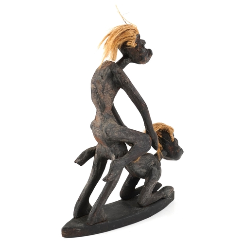 201 - A late 20th century African erotic carving, the two male figures, copulating with coir woven hair on... 