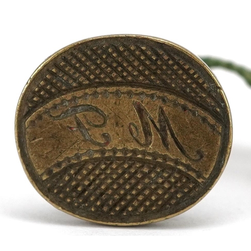 132 - A late 19th century brass seal, the oval stamp initialled P M, with an attached German label, dated ... 