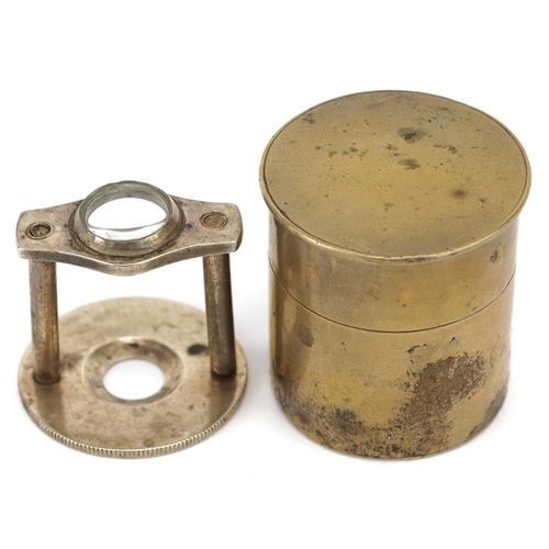 1190 - A brass cased stamp magnifier, circa 1920, enclosing a platform fitted with a lens, diameter 25mm.